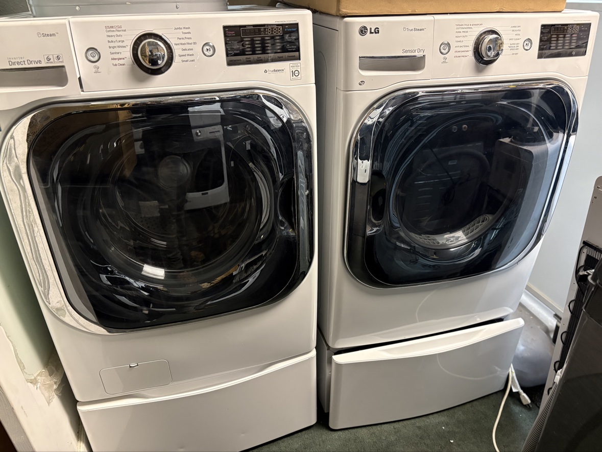 White LG Mega front-load washer and dryer set on pedestal drawers