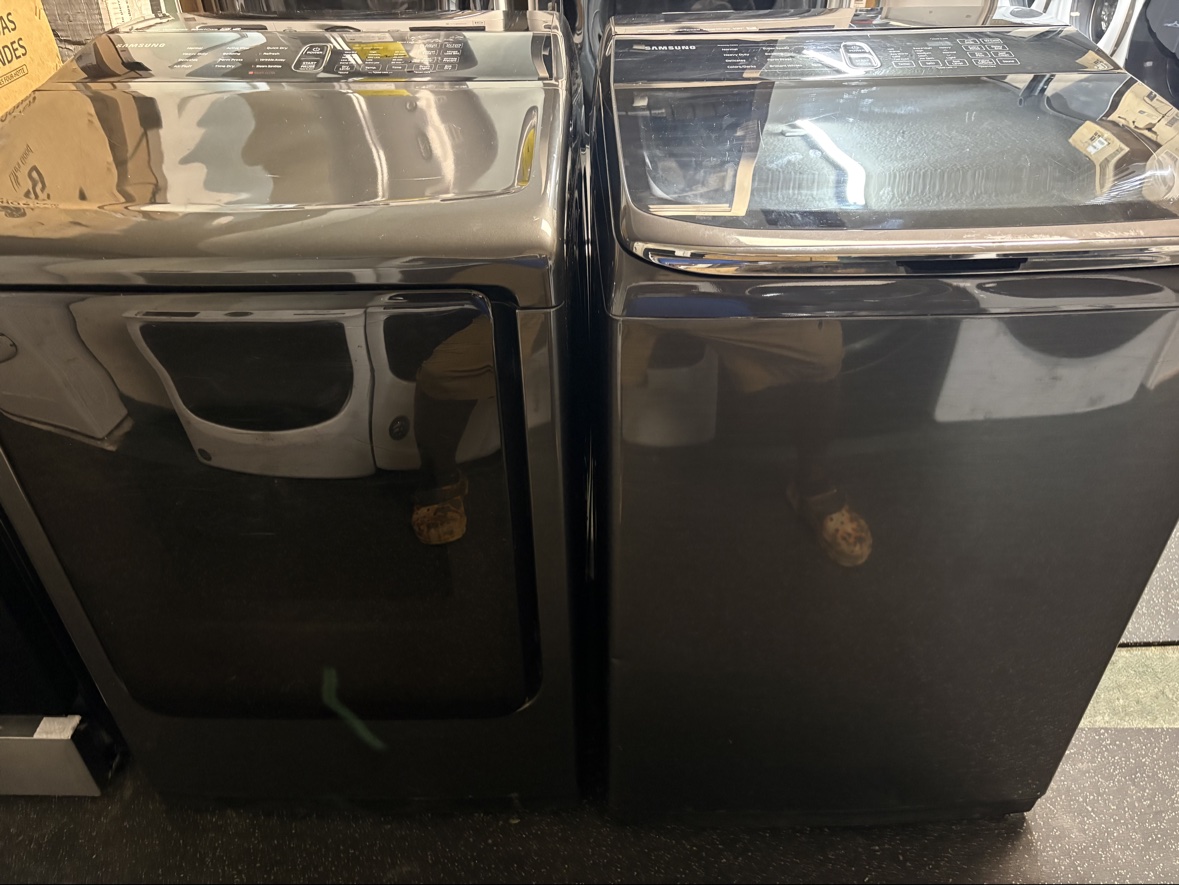 Matching black stainless Samsung VRT Plus top-load washer and dryer set on the appliance floor